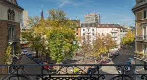uma vista para uma rua da cidade a partir de uma varanda em Saint Georges Hotel em Zurique