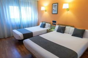 A bed or beds in a room at Hotel Alda Guijuelo