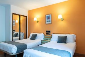 A bed or beds in a room at Hotel Alda Guijuelo