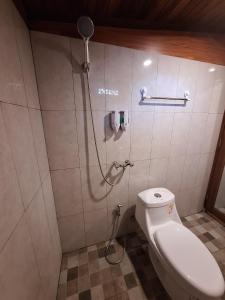 a bathroom with a toilet and a shower at Kubu Telaga Guest House in Uluwatu +6 photos