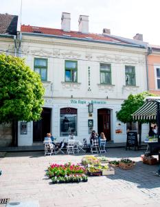 pessoas sentadas em cadeiras em frente a um edifício em Penzion Villa Regia em Košice