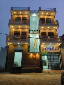 a tall brick building with lights on it at Kamal kishori Dham Guest house in Barsāna