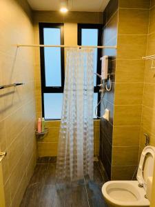 a bathroom with a shower curtain and a toilet at Cozy 2B at Midhills Genting in Genting Highlands