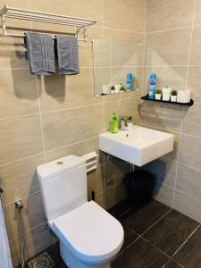 a bathroom with a white toilet and a sink at Cozy 2B at Midhills Genting in Genting Highlands +6 photos