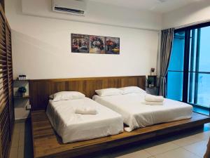 a bedroom with two beds with white sheets at Cozy 2B at Midhills Genting in Genting Highlands