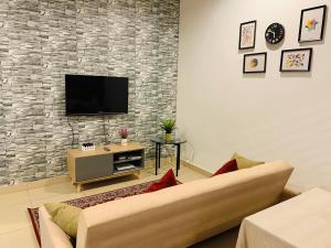 a living room with a couch and a tv at Cozy 2B at Midhills Genting in Genting Highlands