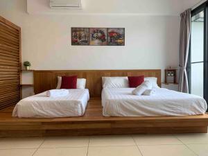 two beds on a wooden bench in a room at Cozy 2B at Midhills Genting in Genting Highlands