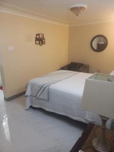 a bedroom with a bed and a table with a lamp at Finest Accommodation Russell Heights Apt #A in Kingston