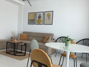 a living room with a couch and a table and chairs at Ammos Apartment Mamaia in Mamaia