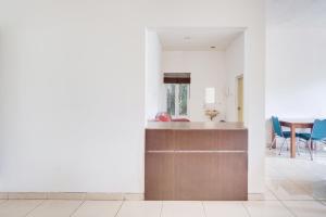 ボゴールにあるHotel O Bogor near Taman Safari formerly Hotel Rudian 2の白い壁と青い椅子のあるキッチンとダイニングルーム