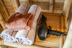 two towels and a blow dryer on a wooden table at Tegal Bamboo Cottages & Private Hot Spring in Baturaja