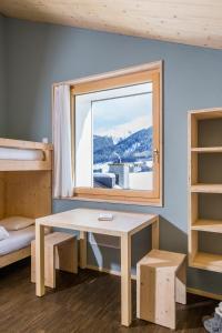 ein kleines Zimmer mit einem Tisch und einem Fenster in der Unterkunft Nova Casa Spinatscha Sedrun in Sedrun