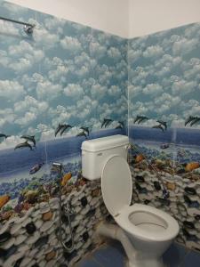 a bathroom with a toilet with birds on the wall at Double D D Homestay in Dirang Dzong