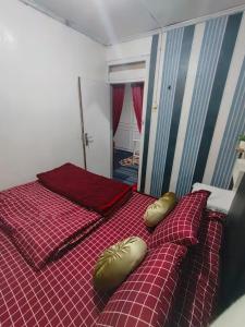a bedroom with a bed with gold pillows on it at Homestay Gaharu Syariah Dieng in Dieng