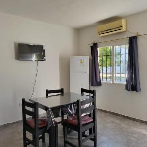 a kitchen with a table and chairs and a refrigerator at Hospedaje "Crisbel" en Las Catitas in Las Catitas