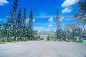 an empty parking lot with trees and a building at Hotel O Bogor near Taman Safari formerly Hotel Rudian 1 in Bogor