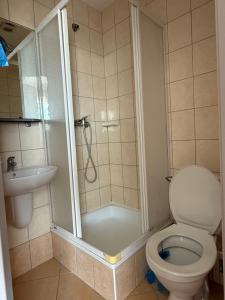 a bathroom with a shower and a toilet and a sink at Pensjonat Wiktoria in Międzywodzie