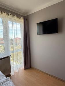 a bedroom with a flat screen tv on the wall at Pensjonat Wiktoria in Międzywodzie