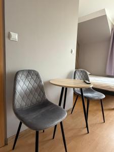 two chairs and a table in a room with a bed at Pensjonat Wiktoria in Międzywodzie