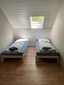 two beds in a small room with a window at EMAS 8 Wohnung mit 2 Einzelbetten, Küche, Dusche, TV in Krefeld