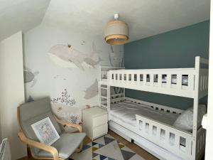 a childs room with a white bunk bed and a chair at Maison Familiale de Centre-Ville in Dives-sur-Mer