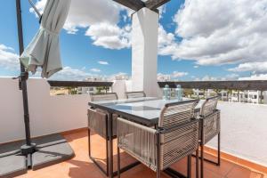 a balcony with a table and chairs and an umbrella at La Terraza Azul - las terrazas de la torre - regio murcia in Torre-Pacheco