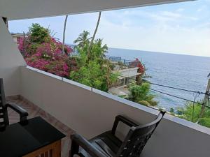 a balcony with a view of the ocean at Hotel Thiruvathira in Trivandrum