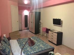 a bedroom with a bed and a dresser and a television at Mini-Hotel Silver in Balashikha