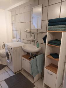 łazienka z umywalką i pralką w obiekcie Ruhiges Apartment nahe Innenstadt und Kliniken w mieście Erlangen +6 zdjęć