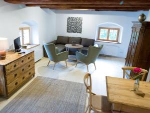 ein Wohnzimmer mit einem Sofa, einem Tisch und Stühlen in der Unterkunft Apartement Schlaf Gut - mitten in der Wachau in Weissenkirchen in der Wachau