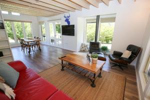 a living room with a red couch and a table at Abby's Cottage - Cosy couples retreat in Wandiligong