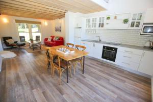 a kitchen and living room with a table and chairs at Abby's Cottage - Cosy couples retreat in Wandiligong