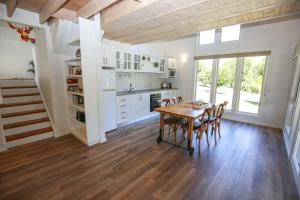 a kitchen and dining room with a table and chairs at Abby's Cottage - Cosy couples retreat in Wandiligong