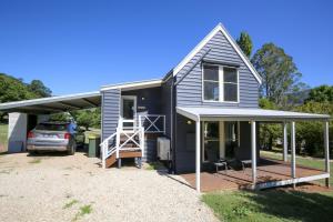 a small house with a porch and a deck at Abby's Cottage - Cosy couples retreat in Wandiligong