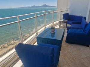 a balcony with blue chairs and a table and the ocean at The bleu sea in Tunis