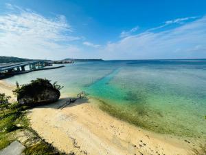 a view of a beach with a bridge and the water at Churana Resort Motobu in Motobu