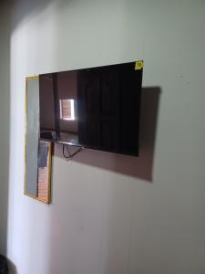 a flat screen tv hanging on a wall at Adinam's Beach Retreat in Nyanyanu