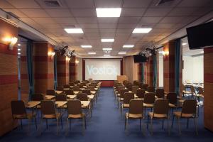 a room with rows of tables and chairs in front of a screen at Vostok Hotel in Tyumen
