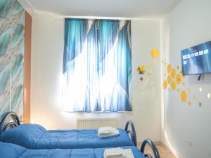 a bedroom with a blue bed and a window at Affittacamere DaME in Foligno +9 photos