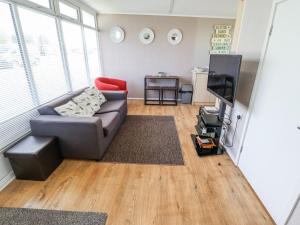 a living room with a couch and a tv at 68 Cherry Park in Skegness