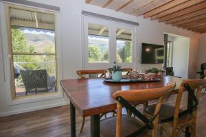 a dining room with a wooden table and chairs at Bonnie's Cottage - Peaceful retreat in Wandiligong