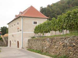 un edificio con una pared de piedra junto a un árbol en Apartement Schlaf Gut - mitten in der Wachau, en Weissenkirchen in der Wachau