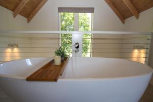 a large white tub in a bathroom with a window at Bonnie's Cottage - Peaceful retreat in Wandiligong +15 photos