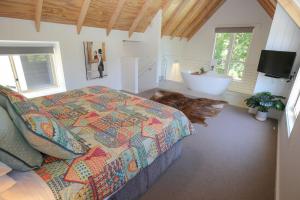 a bedroom with a bed and a bathroom with a tub at Bonnie's Cottage - Peaceful retreat in Wandiligong