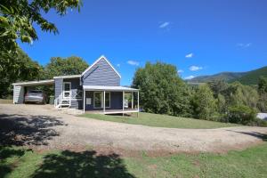 a tiny house with a porch and a driveway at Bonnie's Cottage - Peaceful retreat in Wandiligong
