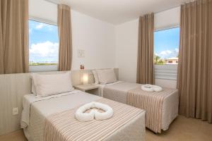 a hotel room with two beds with towels on them at Quintas Private Residence in Costa do Sauipe