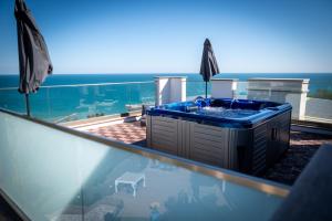 a hot tub on a balcony with a view of the ocean at Queen's Penthouse Balchik apartment in Balchik
