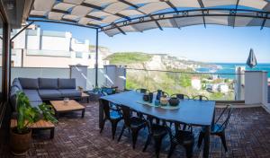 a patio with a blue table and chairs and a couch at Queen's Penthouse Balchik apartment in Balchik