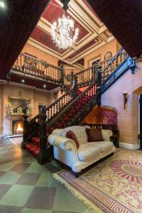 ein Wohnzimmer mit einem Sofa und einer Treppe in der Unterkunft Maenan Abbey Hotel in Llanrwst