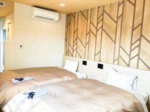 a room with two beds and a wall at HOTEL LiVEMAX Toyooka in Toyooka +1 photo